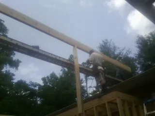 Carpenter setting a ridge beam over a new addition frame — Ice Dam Removal by Roofing Brothers in Dungannon