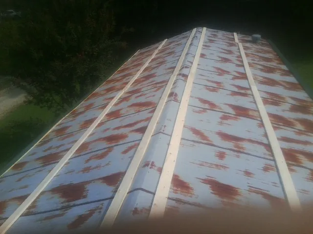 Rusted metal roof panels with new wood purlins before replacement — Storm Damage Roof Repair in Dungannon by Roofing Brothers