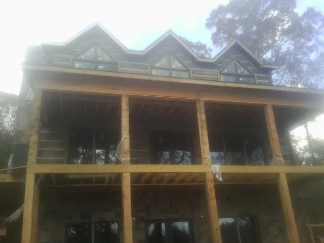 Dormers and porch framing on a large log home under construction — Roof Coating work by our crew in Dungannon